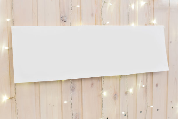 测谎、照明、室内装饰理念。浅色木板墙的背景上有许多闪烁的灯光和长长的干净的白色广告牌素材图片