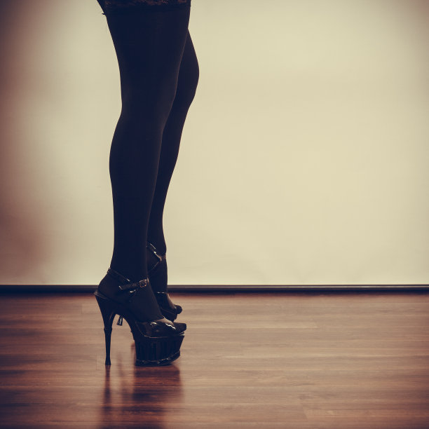 性感的女性长腿在黑色。图片下载