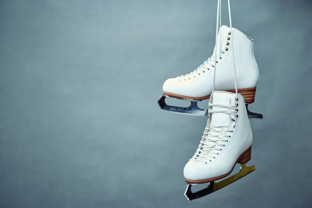 灰色背景上系着鞋带的女子冰鞋。素材图片