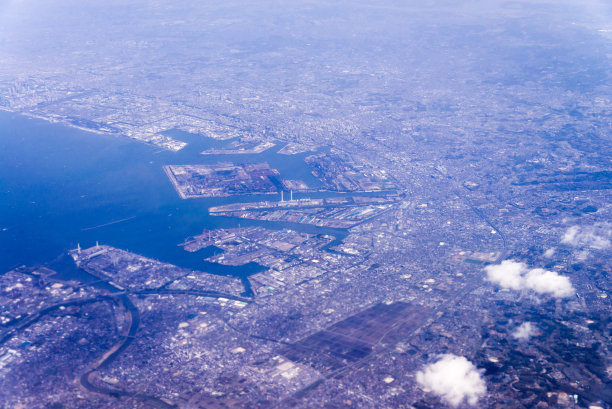 日本东京川崎工业区鸟瞰图从窗口飞机与城市和海洋背景，日本东京川崎图片下载