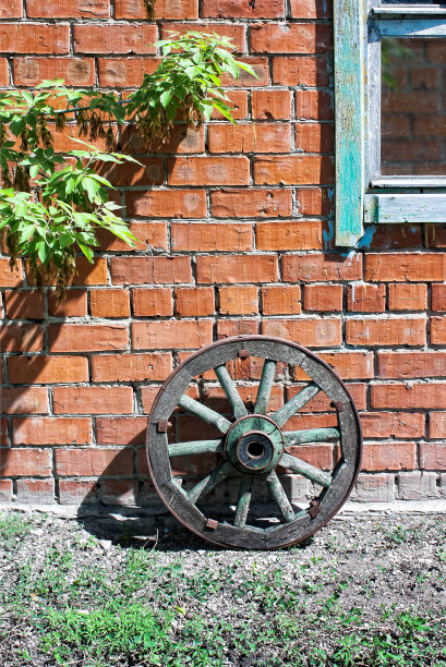 马车轮子靠在砖墙上图片下载