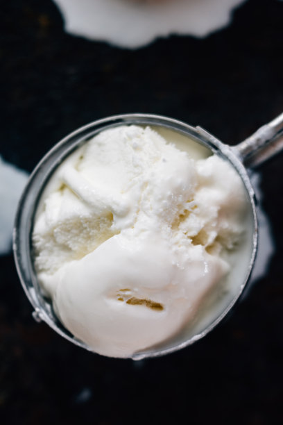 冰淇淋在金属冰淇淋勺里开始融化。图片下载