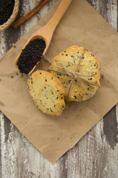 黑木背景上的芝麻饼干，芝麻和牛奶图片下载