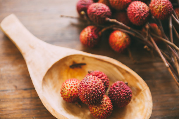 一堆荔枝放在木勺上。新鲜健康的水果。食品的背景素材图片