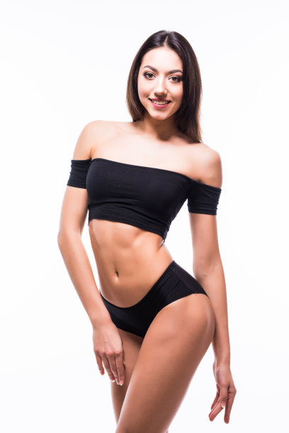 笑运动女孩在黑色内衣摆姿势在灰色背景。照片迷人的女孩与苗条的身材。美容和身体护理理念图片下载