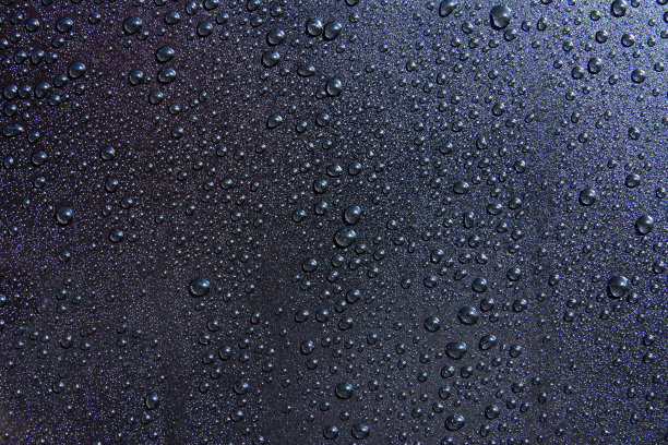 水滴在黑色背景上。水滴在黑色纹理上图片下载
