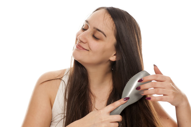 年轻美丽的女子梳理她的长发图片下载