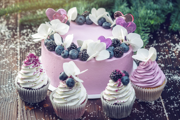 紫色美丽的蛋糕装饰莓，黑莓和蓝莓在上面的纸杯蛋糕在节日的桌子上图片下载