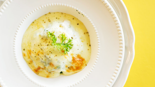 白盘子上烤菠菜和芝士。图片下载