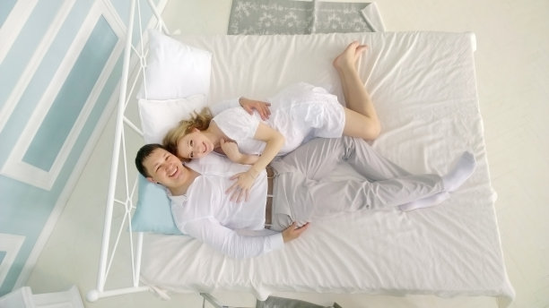 深情的丈夫拿着吉他和怀孕的妻子躺在床上图片下载