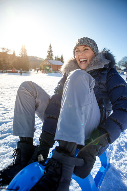 快乐的女人乘坐雪橇下山图片下载