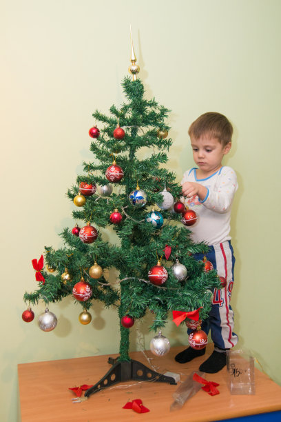 男孩装饰新年树图片下载