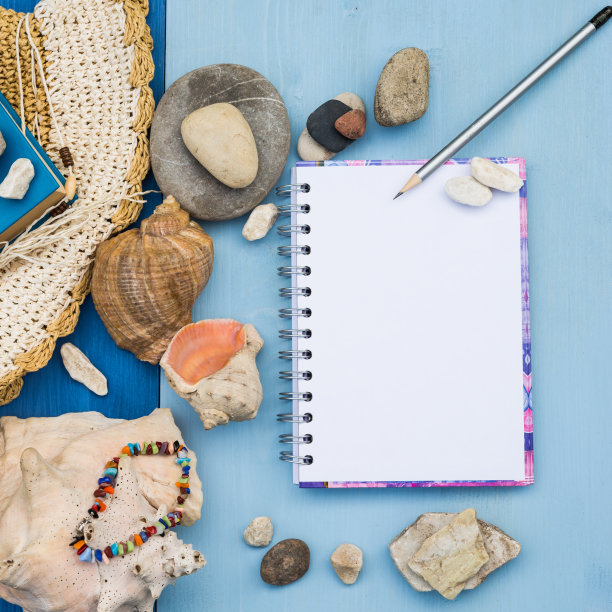 速写本模拟。夏季海上度假模型的背景。笔记本空白页模型与旅游和度假项目蓝色木制桌子。海贝壳，海卵石。本空间图片下载