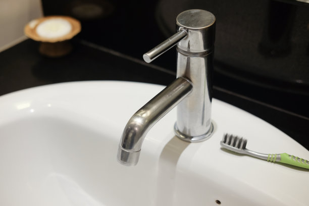 白色浴室水槽中的水龙头和牙刷图片下载