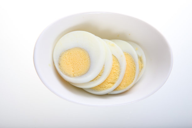 白盘子上的煮鸡蛋切片图片下载