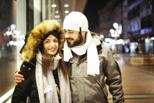 美丽的年轻情侣在城市的街道上享受圣诞或新年之夜。图片下载