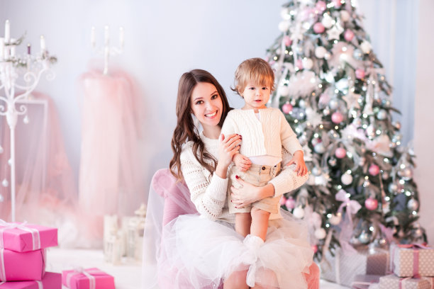 母亲和儿子在圣诞树上图片下载