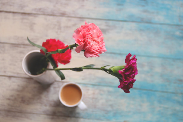 美丽的春花和一杯热腾腾的奶茶的复古照片。图片下载