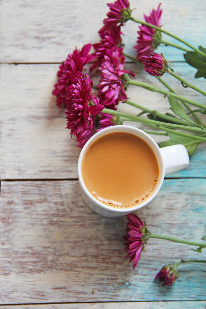 美丽的春花和一杯热腾腾的奶茶的复古照片。图片下载