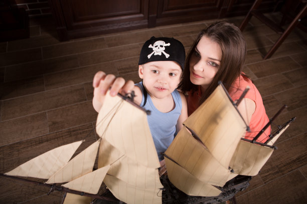 孩子假装水手。家庭母亲和小儿子在玩复古的航海用品。家人在家里玩得开心。旅行和冒险的概念。在海盗游戏。图片下载