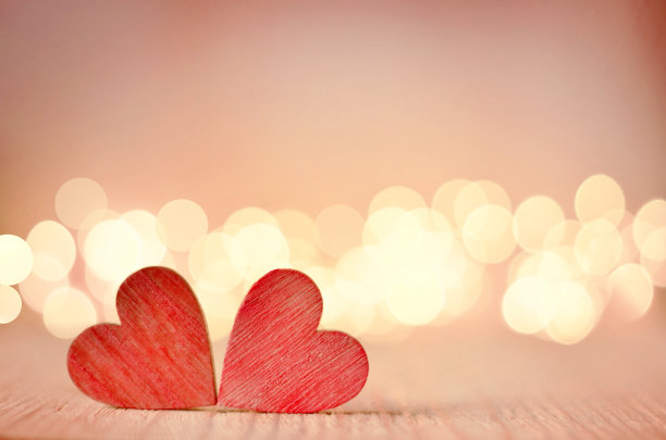 木桌子上的心和背景是一个散景。素材图片