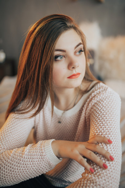 漂亮女人坐在家里的床上图片下载