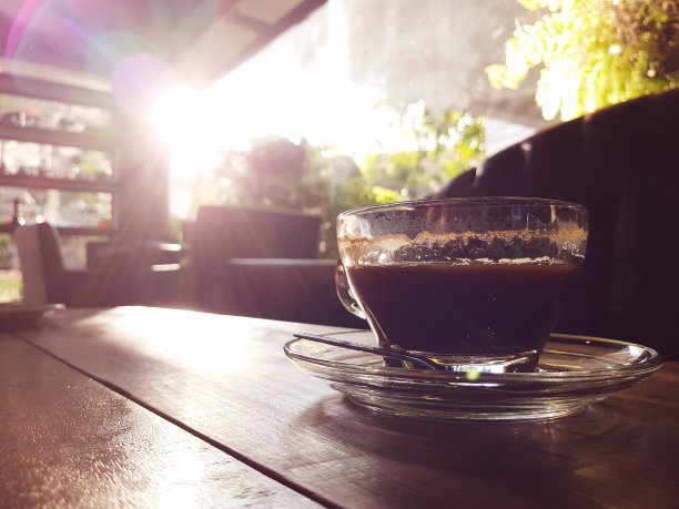 咖啡杯放在木桌上，有镜头光晕和复制空间图片下载