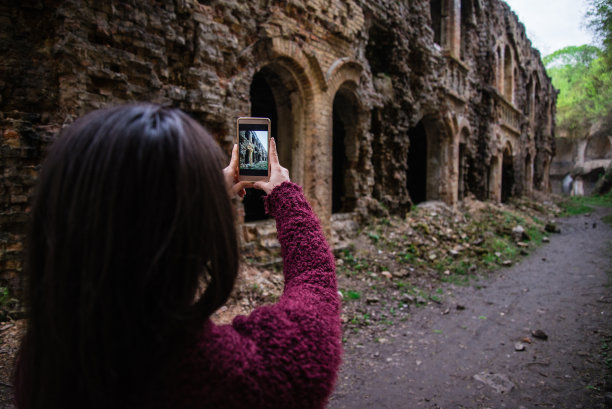 年轻的女游客拍摄古老的废墟图片下载