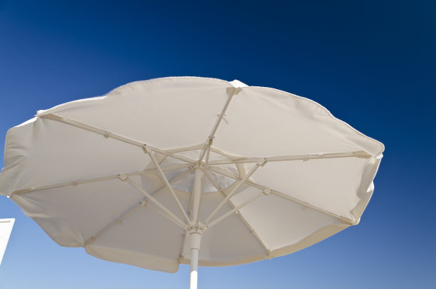 沙滩伞映衬着海滩上蔚蓝的天空图片下载