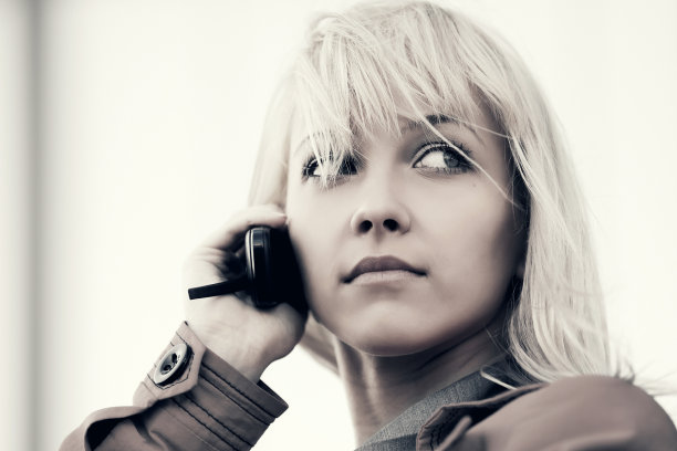 年轻时尚的金发商务女性在室外打电话图片下载