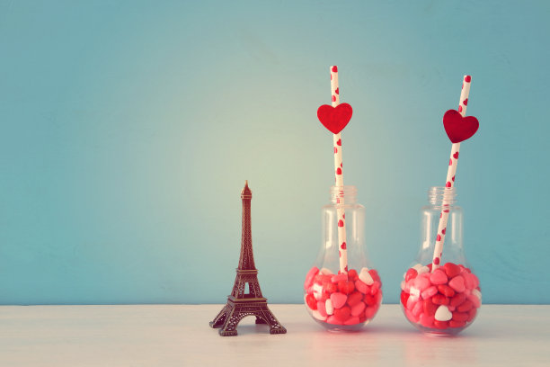 情人节的浪漫背景是白色的桌子上放着心形糖果的塑料灯泡。图片下载