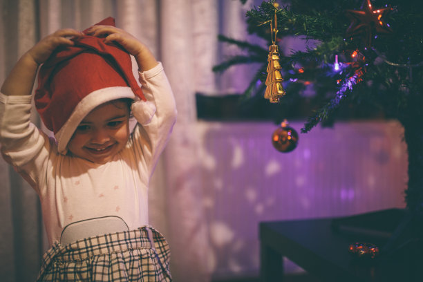 可爱的小女孩装饰圣诞树图片下载