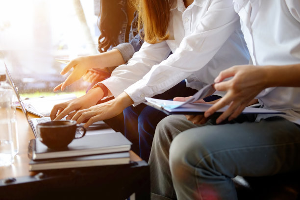 这是一群同事开会时在笔记本电脑上讨论问题的照片图片下载