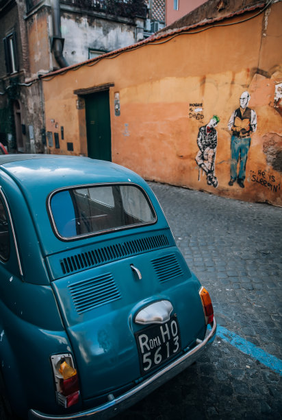 老式的意大利蓝色汽车在鹅卵石街道上图片下载