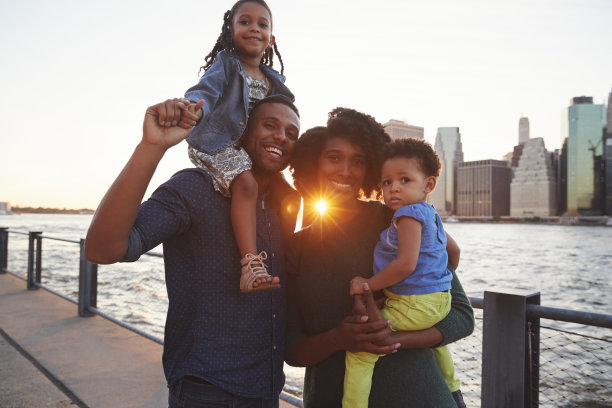 年轻的一家人带着女儿站在码头上素材图片