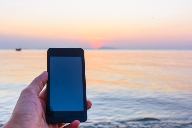 概念和想法使用智能手机在海滩上放松图片下载