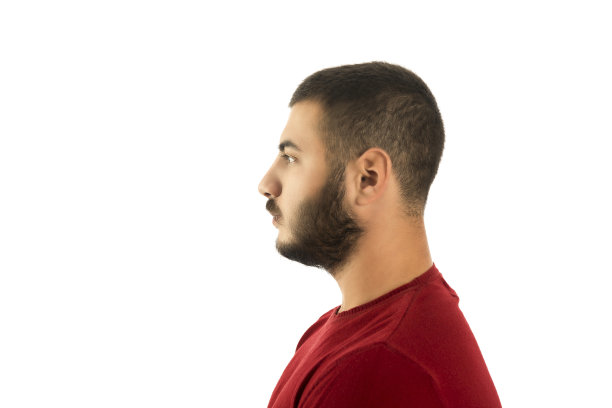 侧面的观点，严肃的年轻人看着远离白色的背景图片下载