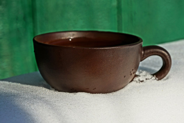 大的棕色杯子与饮料在户外的雪图片下载