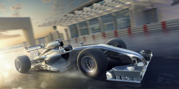 在日落时在赛道上高速行驶的赛车素材图片