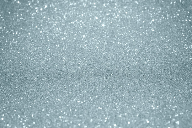 银色闪光纹理背景与模糊的灯光效果和闪闪发光的粒子。闪闪发光的银光或闪亮的雪灯为现代时尚的节日圣诞背景设计模板图片下载