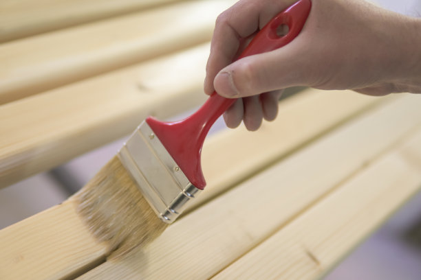 一个年轻人正在画一张旧木桌图片下载