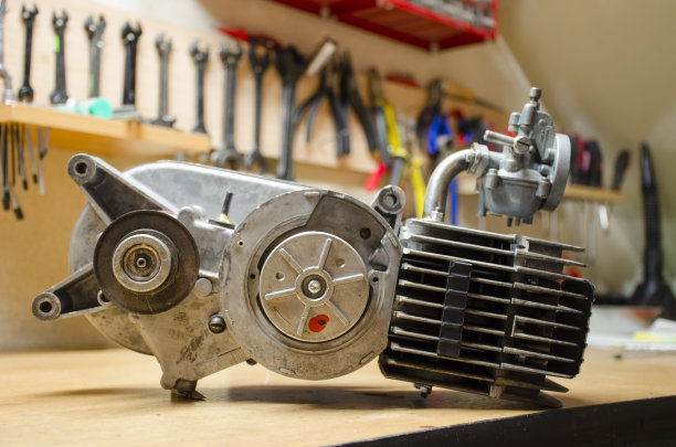 旧引擎从小捷克摩托车改造后与模糊的工具在背景。图片下载