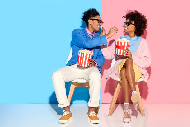 一对夫妇坐在椅子上吃爆米花图片下载