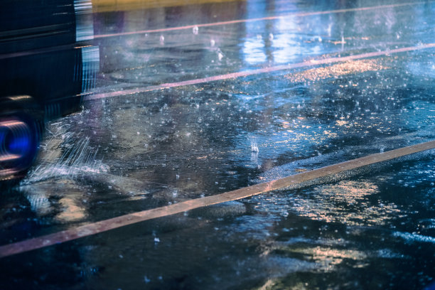 汽车在雨中驾驶在潮湿的道路上带着前灯图片下载