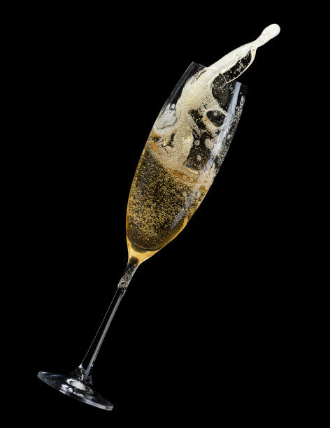 黑色背景上，香槟从玻璃杯中喷溅而出图片下载