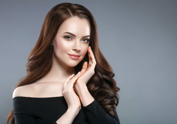 女人美丽健康的皮肤和发型，黑发与长发在黑色背景的女性肖像。图片下载