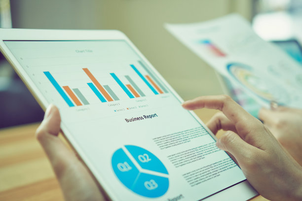 商业女性拿着平板电脑屏幕上的财务总结。向团队展示。素材图片