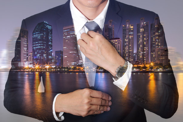 商人拿着领带礼服以好看和城市，城市和湖在晚上作为领导理念。图片下载