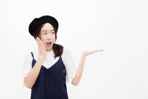 年轻漂亮的亚洲女人在惊讶和惊讶的表情呈现产品姿态-与复制空间。素材图片