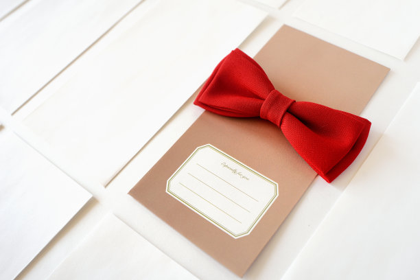 白色背景上有一个红色蝴蝶结的米色礼品信封素材图片